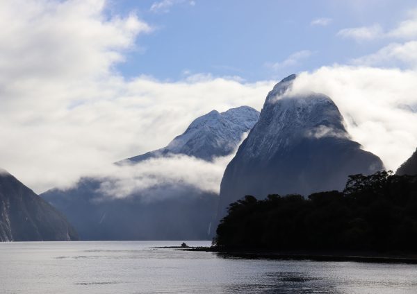 Snow capped tall mountains with some cloud and water
