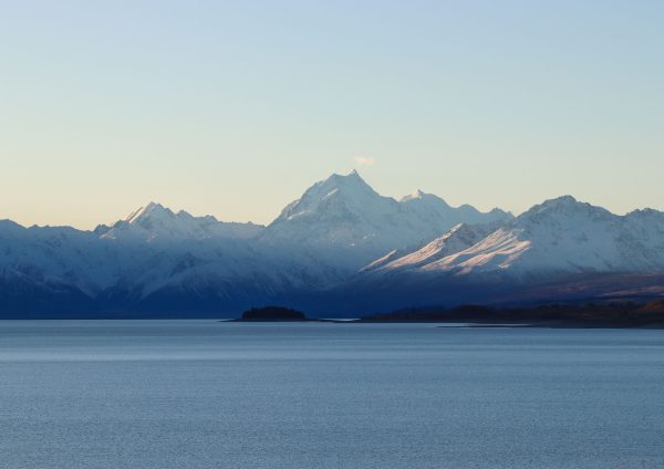 lake with snow capped mountains behind it. sort of dusky soft look